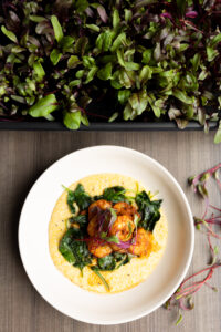 Bowl of shrimp and greens on a table